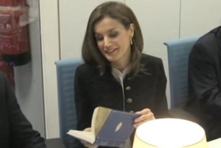 La reina Letizia hojea el libro que le regalaron en la Fundación del Español Urgente.