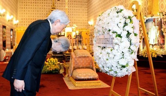 Akihito y Masako colocan una corona de flores junto al féretro del rey Bhumibol de Tailandia.
