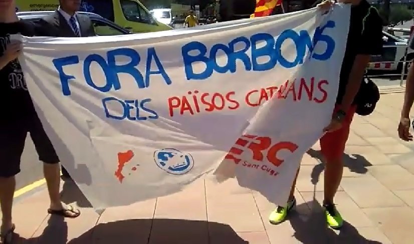 Miembros de las juventudes de Esquerra Republicana de Catalunya con una pancarta contra el rey.